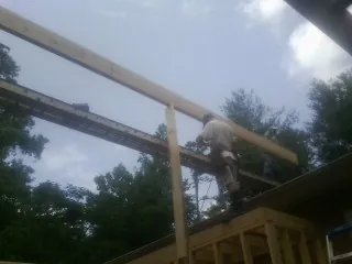 Carpenter setting a ridge beam over a new addition frame — Ice Dam Removal by Roofing Brothers in Woodland